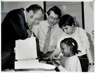 High-tech teaching: Principal Michael Costello leans over a micro computer as teacher Art Witham and student Bryan Figueira, 12, show Sophia McLennan, 8, how to use it