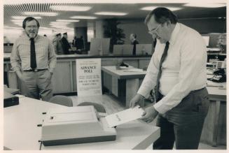 Ballots were fed into machines as demonstrated (right)