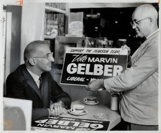 Hard at work, even during his coffee break, campaigning for election in York South is Liberal candidate Marvin Gelber (left). Here he convinces Eglint(...)