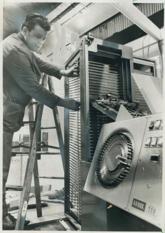 Setting up a $6,000 sorting machine for the computer show is Bob McLean, service representative for A