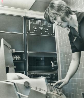 Nicky Fletcher watches a teleprinter as it spews out information that has been fed into the background by a patient