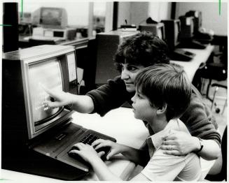 Tomorrow's computer whizzes, Teacher Mary Martorano helps 9-year-old Michael Argles learn how to use a computer at a camp sponsored by Centennial College