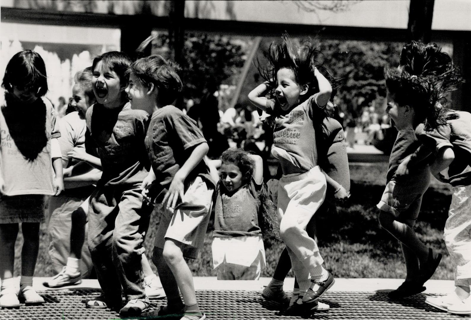 Jumping for joy: Youngsters from the Carmelite Day Nursery were having a great deal of fun on the subway vents at Nathan Phillips Square on Thursday