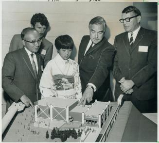 Watched by kimona-clad Japanese girl Ontrio Premier John Robarts last night points out to Japanese Consul Ryoko Ishikwa (left) features of Ontario Pav(...)