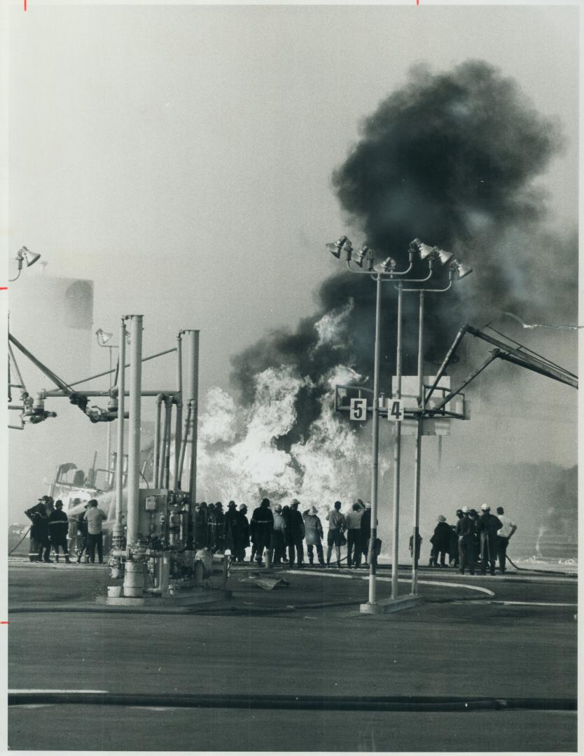 Billowing flames engulf a large tanker truck after it exploded while being loaded with jet fuel in the middle of a shell refinery in Bronte as firemen(...)