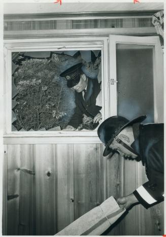 Bomb-blasted basement windows of home at 5 Burleigh Heights Dr., owned by Hawker Siddeley executive P. Y. Davoud, is examined by police and firemen. I(...)