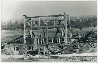 The skeleton of a barn stands guard over a farm north of Oakville, which can be seen in the background