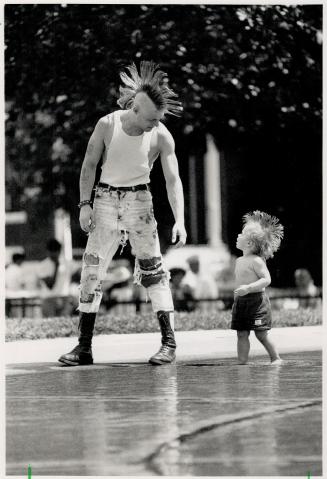 Cooling Off: Matthew Yetman, 2 1/2, and his dad Steve, in matching Mohawk haircuts, take a dip in the pool at Believue Square Park yesterday during an anti-drug concert
