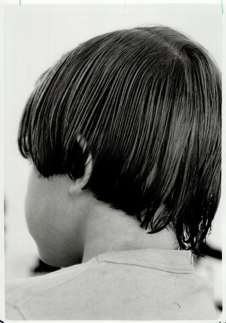 5 To cut hair at the nape of the neck, first comb hair down, pushing it slightly toward the ears