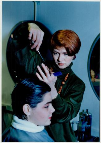 Tallor Ron Burrows measures a man for clothing alternations, while, at top, stylist Dolores cuts a client's hair