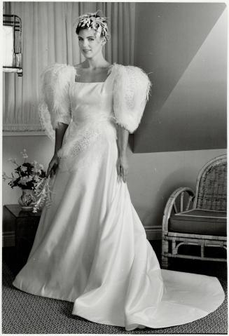Fabulous feathers: Square-necked satin gown with full skirt is adorned with ostrich feathers, rhinestones and pearls, $3,250