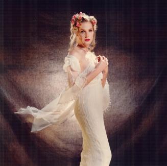 The ethereal bride wears a crinkled silk chiffon slip dress and wrap with handbeaded fringe trim, $595, by Emily Zarb