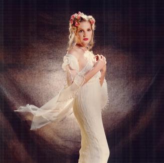 The ethereal bride wears a crinkled silk chiffon slip dress and wrap with handbeaded fringe trim, $595, by Emily Zarb