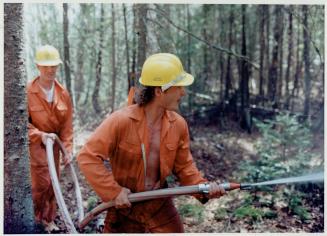 At left, Rick Pelletier works a fire hose