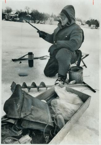 Angling through the ice. Ice fishing has finally started near Keswick, where the ice on Lake Simcoe is eight inches thick. K. Matys of Toronto takes h(...)