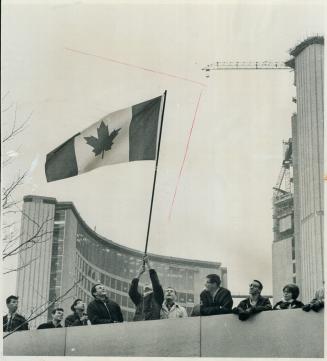 John Groves of the Committe for a Maple Leaf Flag boosts the design he favours by waving it from teh walkway of the new City Hall during Saturday's Gr(...)