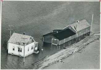 Surrounded by water following the recent storm and flooding along the Lake Erie shoreline, is this farm in the small community of Erieau, south of Chatham. [Incomplete]