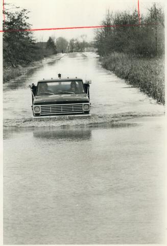 A truck plows through floodwaters on a road near Leamington, one of the areas worst hit by flooding from heavy rain and water blown ashore from Lake E(...)