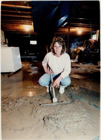 Rising damp: Carol Shearing of Stouffville clears water and silt from the flooded basement of her home