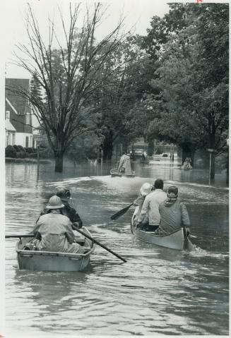 Rescue workers use boats in the streets of Olean, N