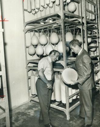 Guy and Sam Lettieri examine finished cheeses in their Toronto plant