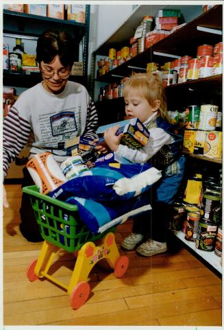 Stocking up: samantha Van Arem, 22 months, and Vivian Harwood, minister at Park Woods United Church pitch in at the Richmond Hill food bank