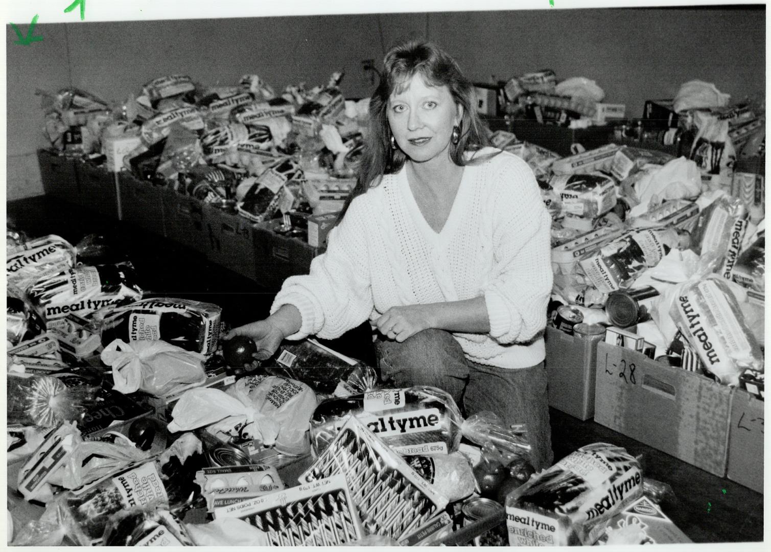 Helping hand: Bonnie Hart at Oshawa's Simcoe Hall Setlement House prepares food boxes for the needy in a city used to one of the nation's lowest unemployment rates