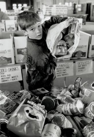 A helping hand, Sean Maxwell, 11, of Mississauga, didi his bit for the Daily Bread Food Bank, sorting and packing groceries for the annual Easter drive at the Mississauga depot