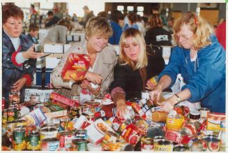 Digging in: Volunteers Sue Gordon, left, daughter Cynthia and Dianne Wilton sort donated food in Daily Bread Food Bank's Mississauga warehouse