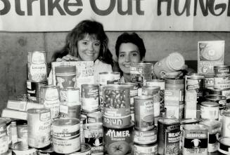 Bases full: Blue Jay wives Chris Whitt, left, and Claudia Cerutti show some of the bounty collected from fans for Metro's 55,000 hungry