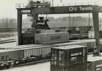 Special crane lifts huge new container units from flatcars at the Canadian National container terminal at Keele St
