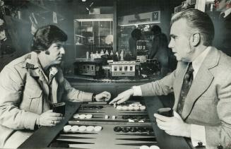 Backgammon Buff Keith Claxton-Olfield, right, explains the fine points of the game to Harry Fiedler, in The Games Room a shop in the concourse of the (...)