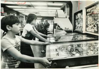 Pinball fans Tommy Bise, 12, left, and Emilio Landolfi, 12, concentrate on their game at the Pinball Emporium on Yonge St. near Dundas St. The noisy, (...)