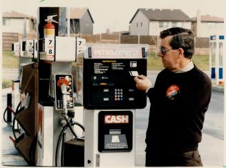 Petro-Canada's Don Vallancourt uses credit card at new self-serve gas station