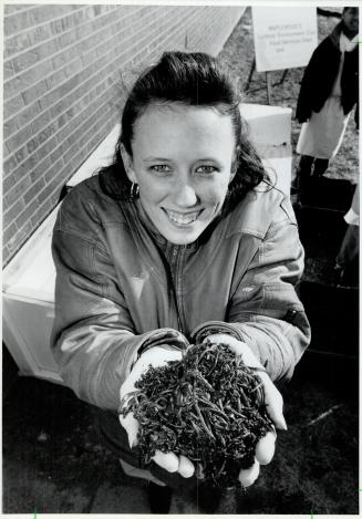 Heap of Help: Carla Mills holds a bunch of worms used by Maplewood high school's compost program
