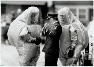 Suiting Up: Firefightes in face masks and anticontamination suits get their ordes from regional chief Larry Casey before entering McCormick Park Recreation Centre where the gas leak occurred