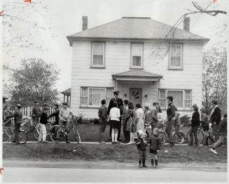 Curious crowds gathered in front of haunted house at 184 Prince Edward Dr. yesterday are ordered away by policeman after rowdy youngsters had banged o(...)