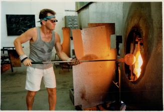 Fierce furnace: Glass blower Ian Forbes works next to a 1,260C (2,300F) oven the size of a suburban garage