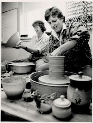 Spinning wheels, Peggy Grigor works at the potters wheel while Barbara Elend examines the finished product