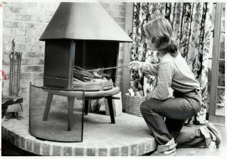 Money saver: Kathleen Ratchford, fifteen, tends fire in the family's Jotul cast-iron woodstove