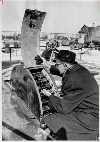 Harold Fromm, rust expert with the Ontario Department of Highways, checks one of the five test rigs at Downsview