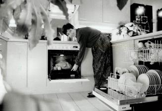 Hanson-Needler's. Suzanne Smith demonstrates environmentally friendly appliances at the company's Esprit condominiums, above