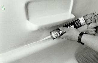 Apply caulking: Left, once insert is installed, silicone caulking is applied around bathtub and ceiling, masking tape placed on the edges of the tub and ceiling make clean-up simple