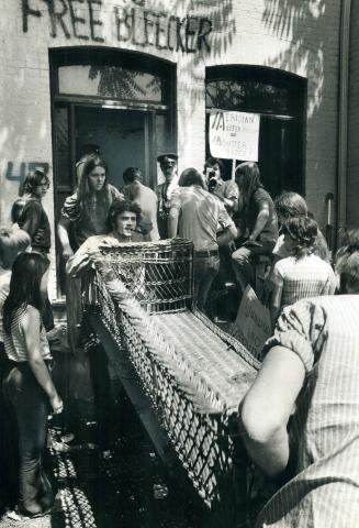 Tenants and friends carry furniture out of a house on Bleecker St