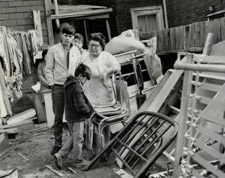 Evicted from home, Mrs. Mabel Driver and her children, stand looking at their furniture piled in a neighbor's yard. With Mrs. Driver are daughter Ivy (...)