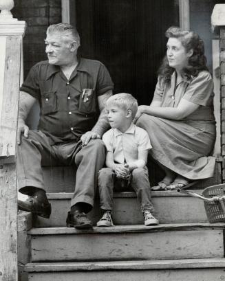 Waiting for bailiff, Tom Bowler, his wife and son, Michael, sit on veranda of their Keewatin Ave