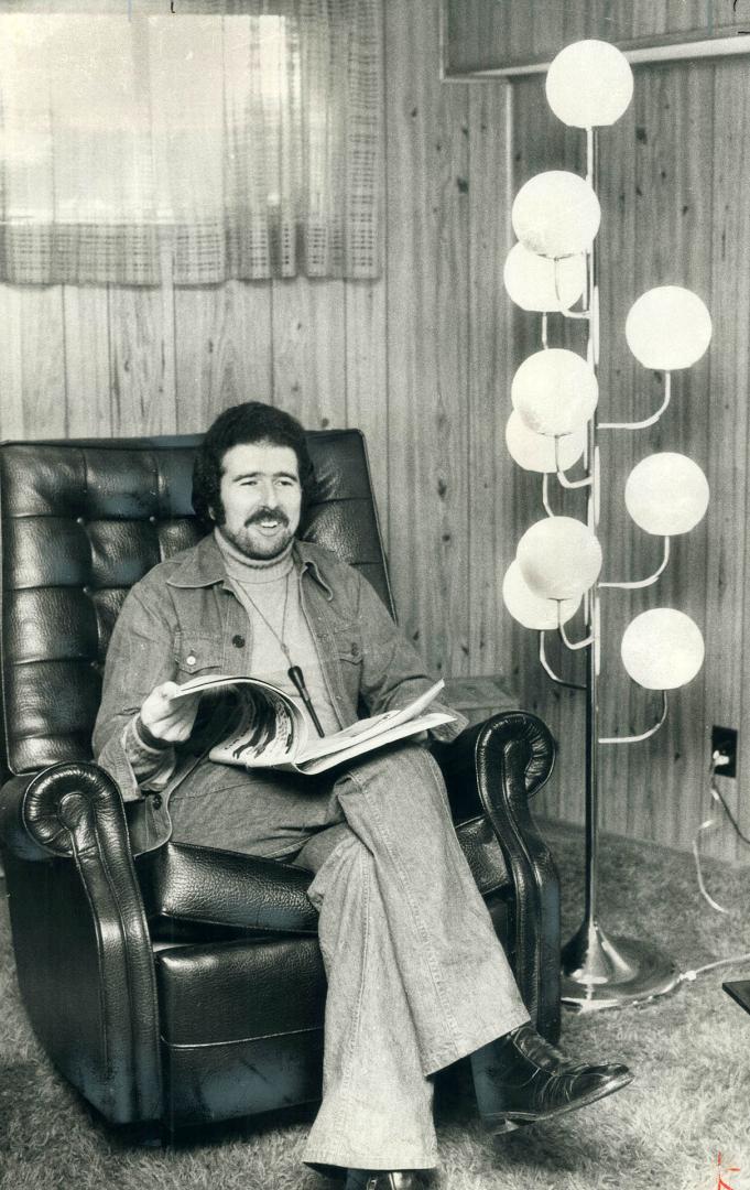 Seymour Schartz finds it comfortable to read with a tree lamp beside him