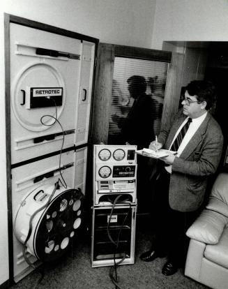 Air leaks: Tony Woods, a house shell specialist, conducts tests, as the blower door he has installed in an East End home creates the effect of a 40km/h wind blowing on the house