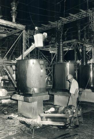 Explosion aftermath: Tom Griffiths, Ontario Hydro's Toronto district manager, stands to the right of the transformer that exploded