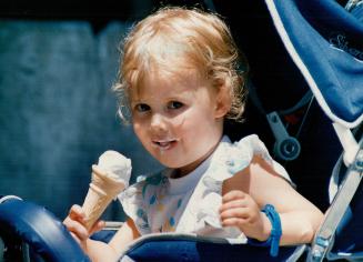 Top 2 1/2-year-old Alanna Cervenak of Toronto beats the heat with a tantalizing taste of ice cream